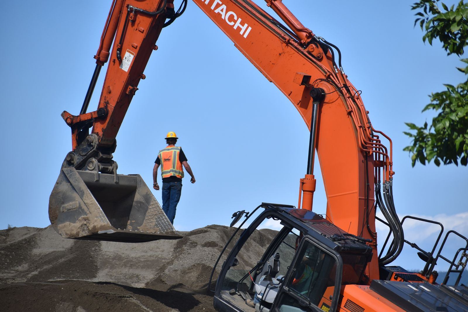 An excavator operator working a large orange machine on site