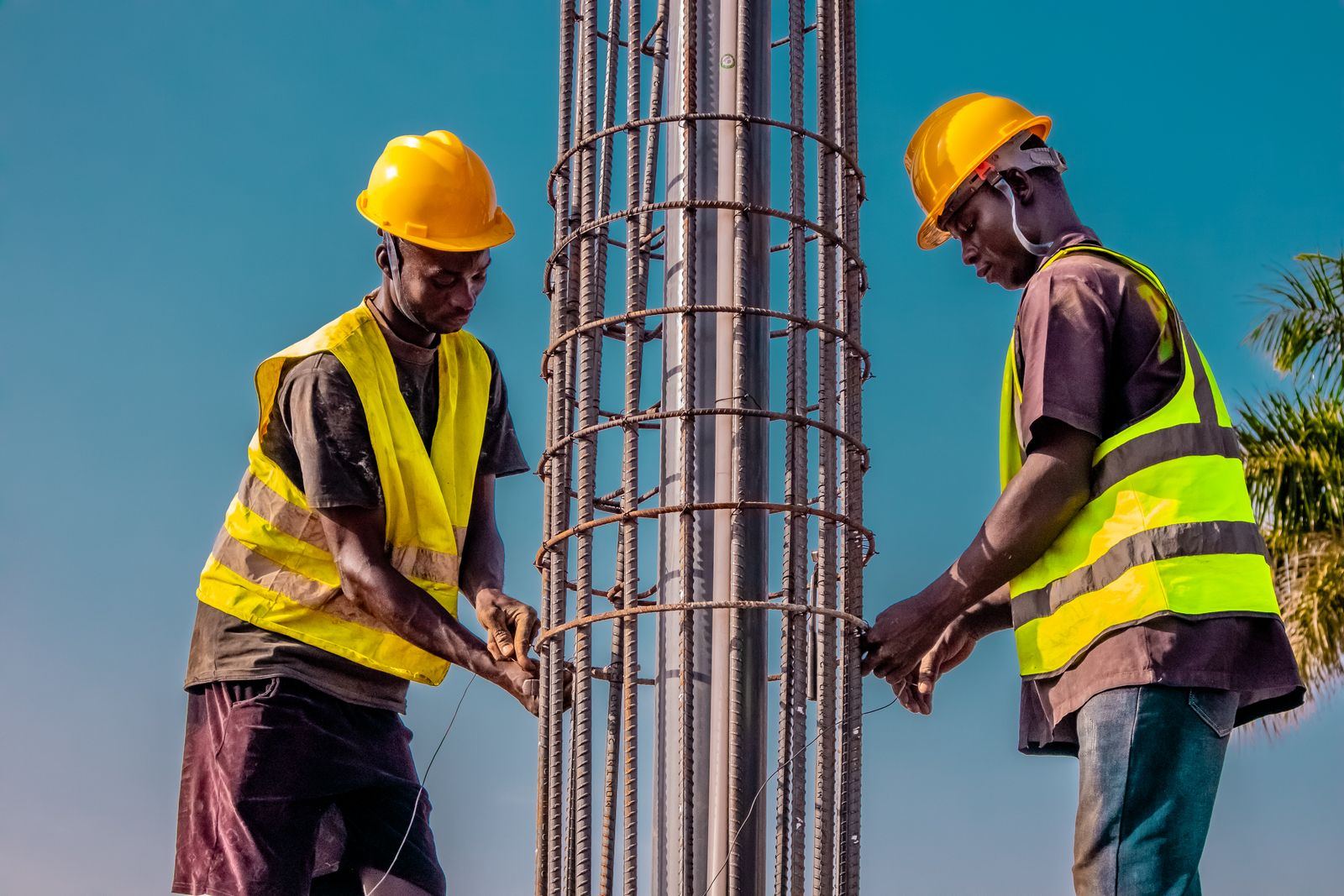 Two workers fixing a steel column together
