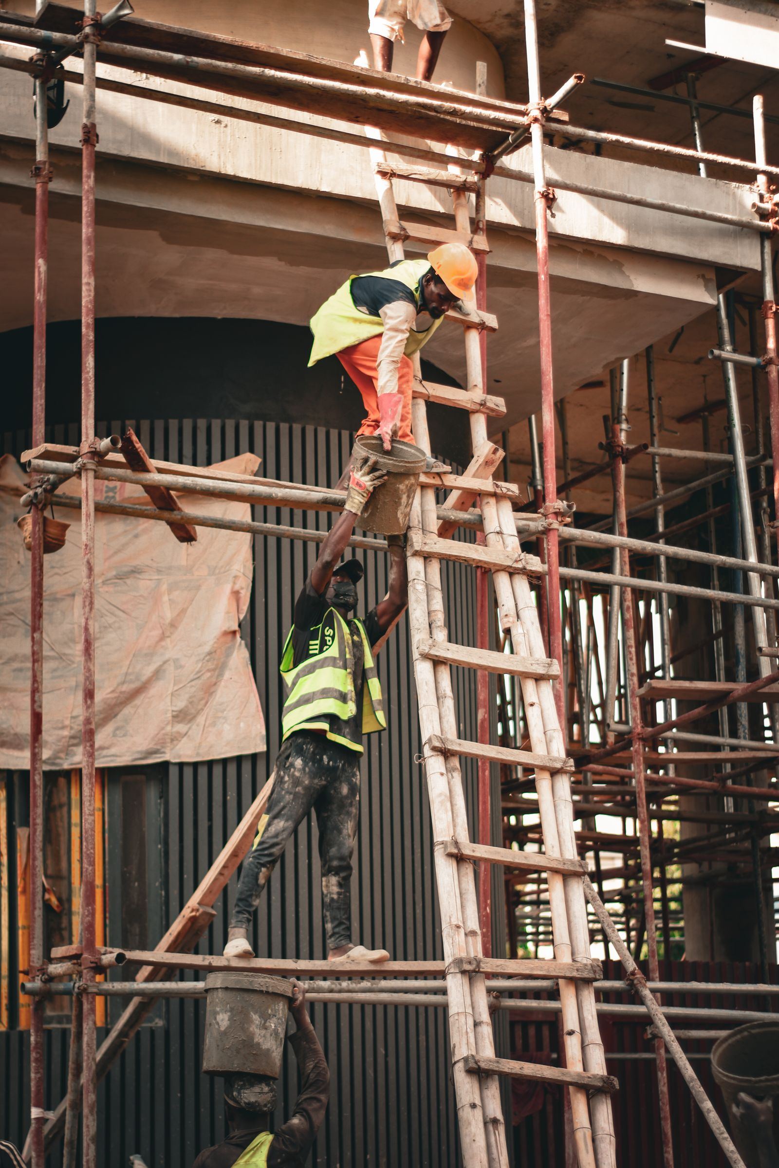 A worker climbing scaffolding on a city building